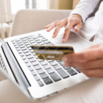 Woman holding a credit card and using computer, online shopping